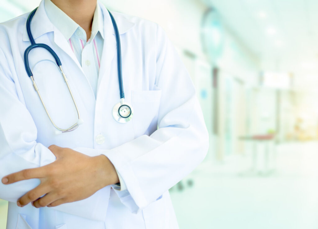 Medicine doctor with uniform stethoscope in hand .The background is a blur of the hospital.There is golden light of the morning shone through the window, looking warm.Healthcare and medical concept.