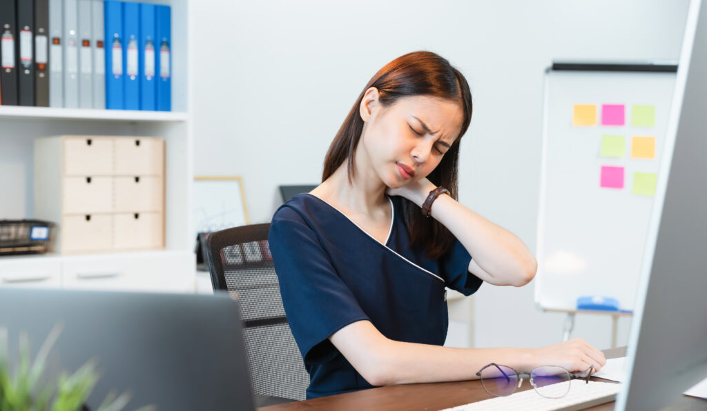 business woman have a neck pain because using the laptop computer and working for a long time. This may be the cause of Office Syndrome.