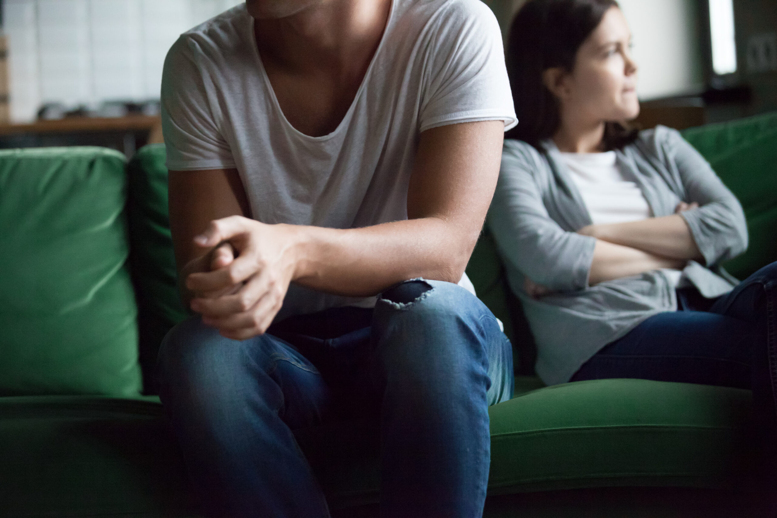 Close up man and woman sitting on sofa and not talking, not looking of each other after quarreling at home Unhappy couple after fight have difficulties, break up, misunderstanding in relations concept